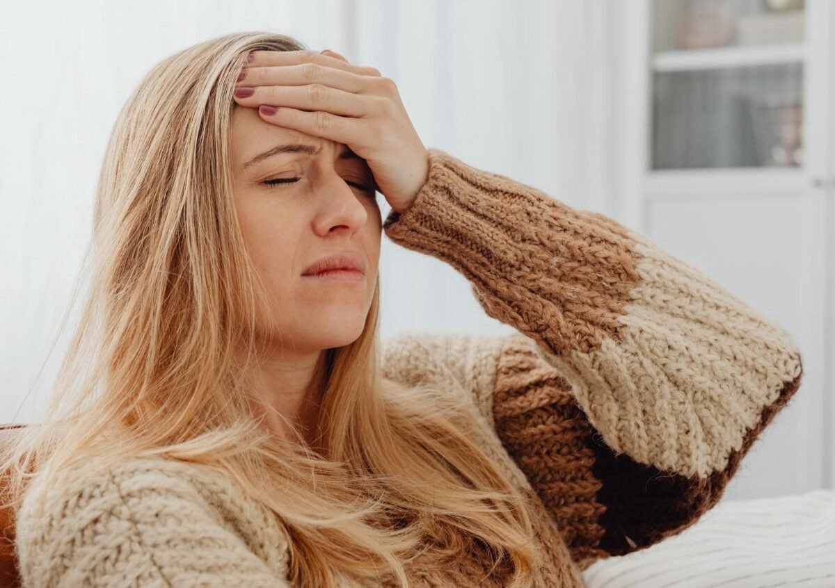Una persona con mal di testa, seduta. Per illustrare i sintomi della “Keto Flu”